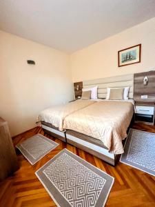 1 Schlafzimmer mit 2 Betten und 2 Teppichen in der Unterkunft Hotel Čile in Kolašin