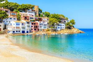 einen Strand mit Häusern und Booten im Wasser in der Unterkunft Appt «  Eichenstein » Begur-Pals in Pals