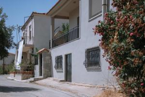 - un bâtiment blanc avec une porte et un balcon dans l'établissement OAZA Thasos, à Prinos