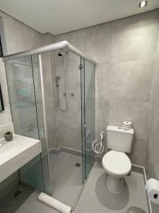 uma casa de banho com um WC e uma cabina de duche em vidro. em Hotel do Vale em Campina Grande