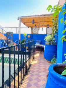 a patio with a blue wall and some plants at RIAD GALIYA in Marrakech