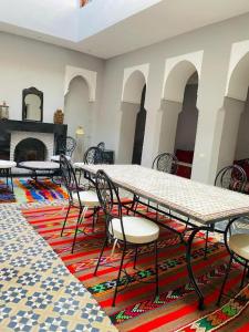a room with a table and chairs and a fireplace at RIAD GALIYA in Marrakech