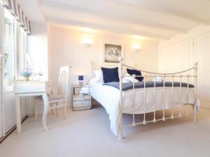 a bedroom with a white bed and a desk and a desk at Potters Barn in Helston