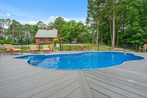 una piscina con terraza de madera y una casa en Persimmon Hollow with GameRoom, en Blue Eye
