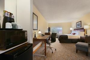 a hotel room with a bed and a desk with a television at Wingate by Wyndham - Chattanooga in Chattanooga +20 photos