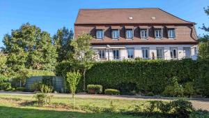 une grande maison avec une haie en face dans l'établissement FeWo Apland, à Landau in der Pfalz