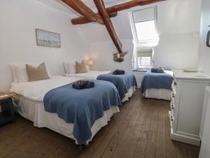 a bedroom with two beds with blue blankets at Yr Ysgubor in Dyffryn