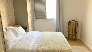 a bedroom with a white bed and a window at AP1203 . CONFORTO, PRATICIDADE E LOCALIZAÇÃO in Maringá