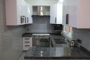 a kitchen with marble counter tops and white cabinets at luxurious Family Apartment in Karachi