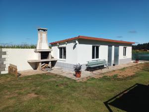 a white house with a lighthouse in a yard at A Casa dos Vellos in Santa Irene