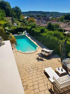 een zwembad met 2 ligstoelen en een patio bij Villa de 5 chambres avec piscine privee jacuzzi et terrasse a Perigueux in Périgueux