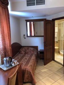 Dormitorio pequeño con cama y espejo en Hotel Ajka 1 en Ajka