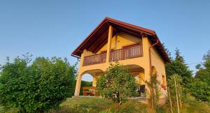 a yellow house with a balcony on top of it at Holiday house and apartments Vale in Duga Resa