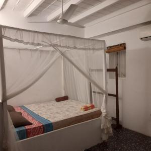 a bedroom with a bed with a canopy at Shoba Traveller's Tree in Galle