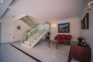 ein Wohnzimmer mit einer Treppe und einer roten Couch in der Unterkunft Preciosa Casa en Yautepec, Morelos. in Yautepec de Zaragoza