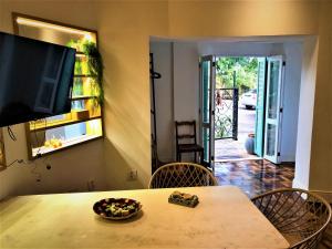 uma mesa de jantar com cadeiras e uma televisão na parede em Apto MILAO na Vila Paraíso, prático e relaxante em Maringá