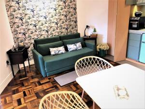 uma sala de estar com um sofá verde e duas cadeiras em Apto MILAO na Vila Paraíso, prático e relaxante em Maringá