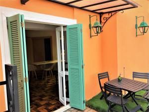 Une porte ouverte s'ouvre sur une terrasse avec une table. dans l'établissement Apto MILAO na Vila Paraíso, prático e relaxante, à Maringá