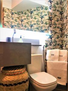 baño con aseo y papel pintado con motivos florales en Apto MILAO na Vila Paraíso, prático e relaxante en Maringá
