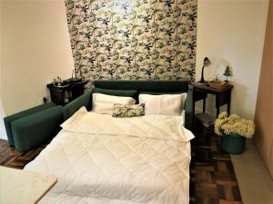 uma cama com um edredão branco num quarto em Apto MILAO na Vila Paraíso, prático e relaxante em Maringá