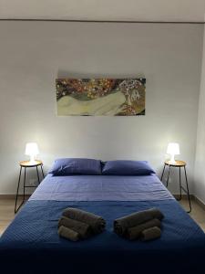 a bedroom with a blue bed with two lamps at casa vacanze Iside in Termini Imerese