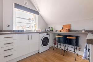 a kitchen with a washer and dryer next to a window at Castle Garden View in Rochester