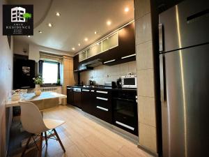 a kitchen with a refrigerator and a table in it at AmurResidence privat-Sauna City Center FamilyConcept in Iaşi