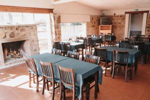 uma sala de jantar com mesas e cadeiras e uma lareira em Apart Hotel Aguasol em Termas del Daymán