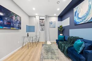 a living room with a blue couch and a table at SWJ G - Save on 2Day or more Stays 25min to Times Sq in New York