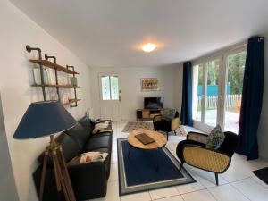 a living room with a couch and a table at Maison dans parc privé, sports et loisirs proche golf du Coudray Montceaux in Le Coudray-Montceaux