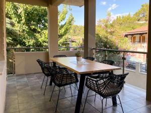 a porch with a wooden table and chairs at Eva's Summer House - ADAMOS HOLIDAYS in Fourka