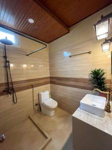 łazienka z toaletą i umywalką w obiekcie Dahilayan Comfy Cabin w mieście Manolo Fortich