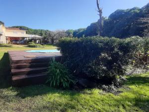 a garden with a wooden deck in the grass at Flor de Lis apartmento, Room 1, Room 2 in Mar del Plata