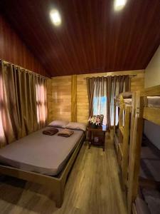 a small bedroom with a bed and a window at Dahilayan Comfy Cabin in Manolo Fortich