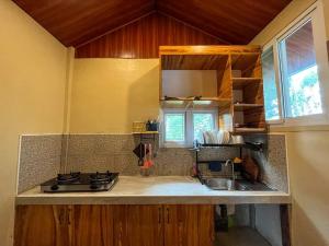 a kitchen with a sink and a counter top at Dahilayan Comfy Cabin in Manolo Fortich