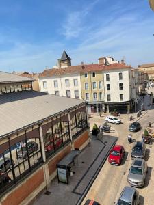 una vista aérea de una ciudad con coches estacionados en un estacionamiento en Vue sur la place des Halles, Art Apparts, en Béziers