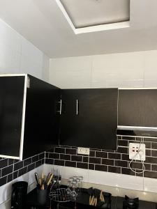 a kitchen with black and white tile on the wall at Seaview Palace in Lekki