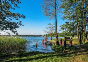 a group of people in the water at a lake at Domki Piękna Góra in Giżycko +9 photos