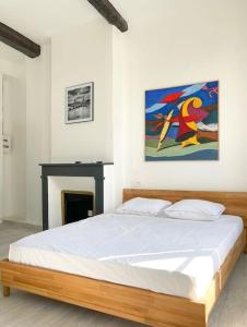 ein Schlafzimmer mit einem Bett und einem Wandgemälde in der Unterkunft Vue sur la place des Halles, Art Apparts in Béziers