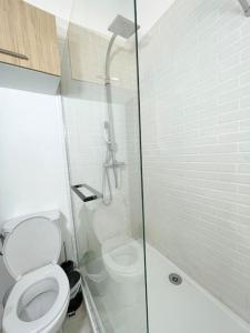 a bathroom with a toilet and a glass shower at Vue sur la place des Halles, Art Apparts in Béziers +20 photos