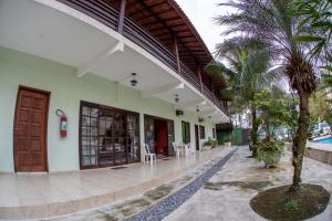 a building with a courtyard with a palm tree at Pousada Praia Enseada - Marvile in Guarujá