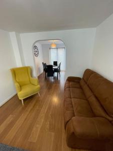 a living room with a couch and a yellow chair at 5 Holborn Spacious Home in Redhill