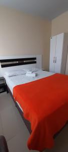 Un dormitorio con una cama con una manta roja. en Kata Suites Floripa, en Florianópolis