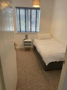 een kleine slaapkamer met 2 bedden en een raam bij 5 Holborn Spacious Home in Redhill