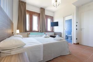1 dormitorio con 1 cama blanca grande y baño en Villa Alessandra, en Campagna
