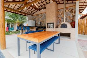 cocina y comedor con mesa de madera y sillas azules en IT01 Triplex 4 Suítes a 350m da Praia do Surf, en Camassari