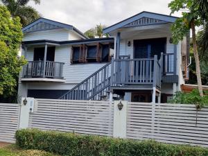 a house with a white fence in front of it at Homestay at Julie's in Cairns