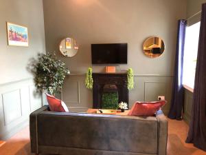 Ffau Bach - Little Den في بيمبروك دوك: غرفة معيشة مع أريكة وتلفزيون