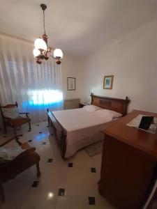 una camera con letto, tavolo e scrivania di appartamento in casa Lai a Desulo
