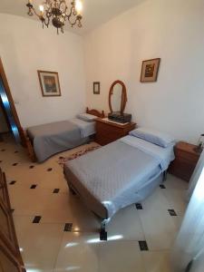 a bedroom with two beds and a mirror at appartamento in casa Lai in Desulo